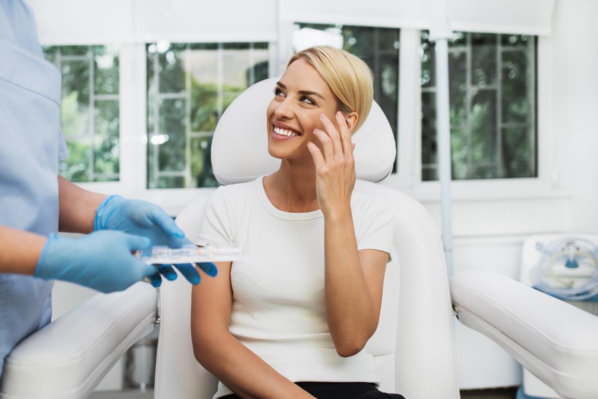 Beautiful and happy blonde woman at beauty medical clinic.