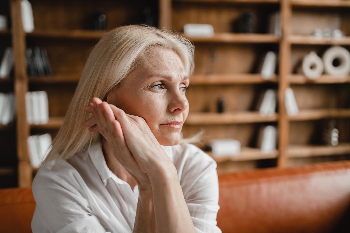 Stressed, sad, tired exhausted, caucasian middle-aged mature woman thinking about menopause.