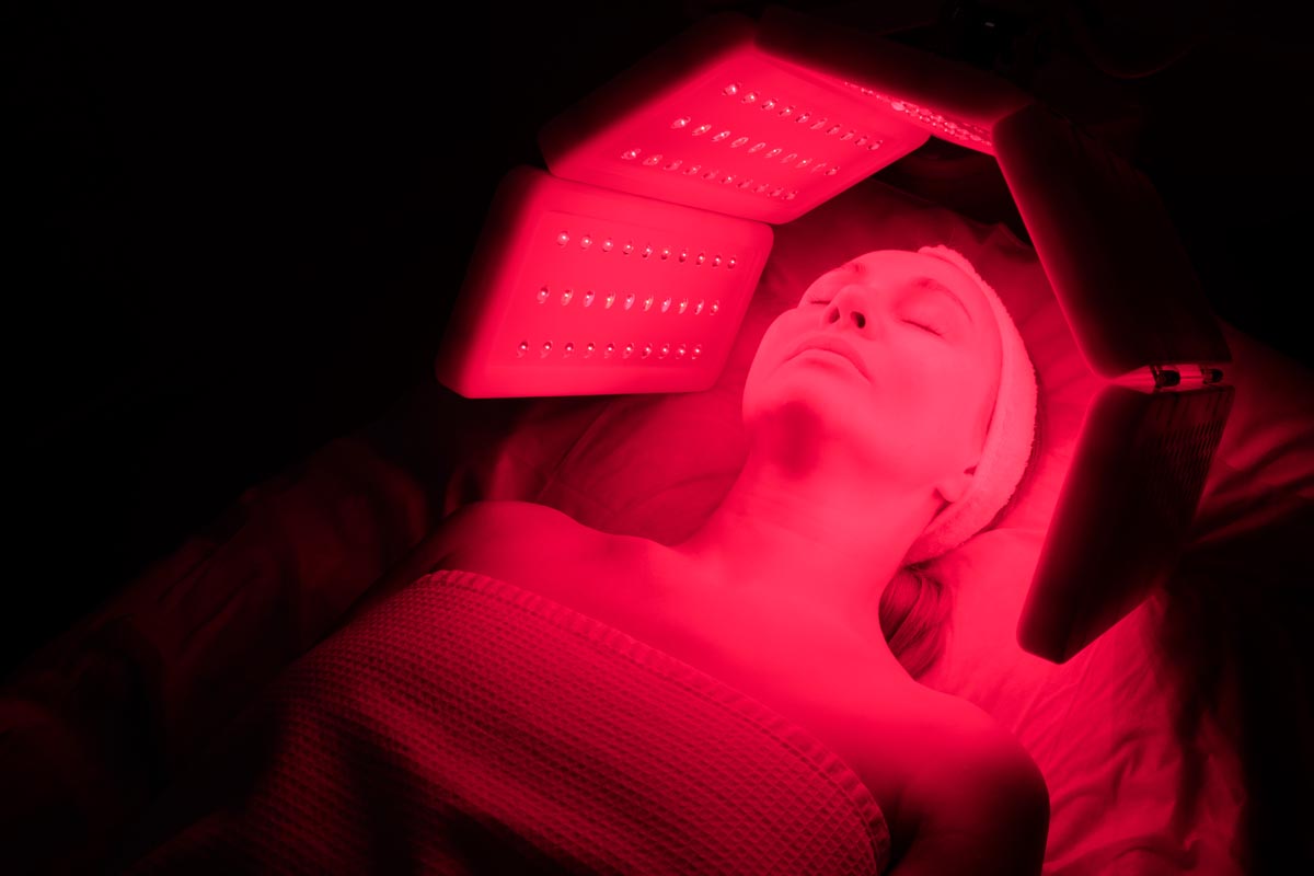 Woman receiving red light treatment.