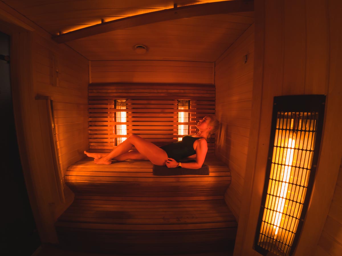 A girl lies in an infrared sauna.