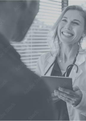 Smiling doctor holding a tablet, engaging with a patient in a bright medical office.